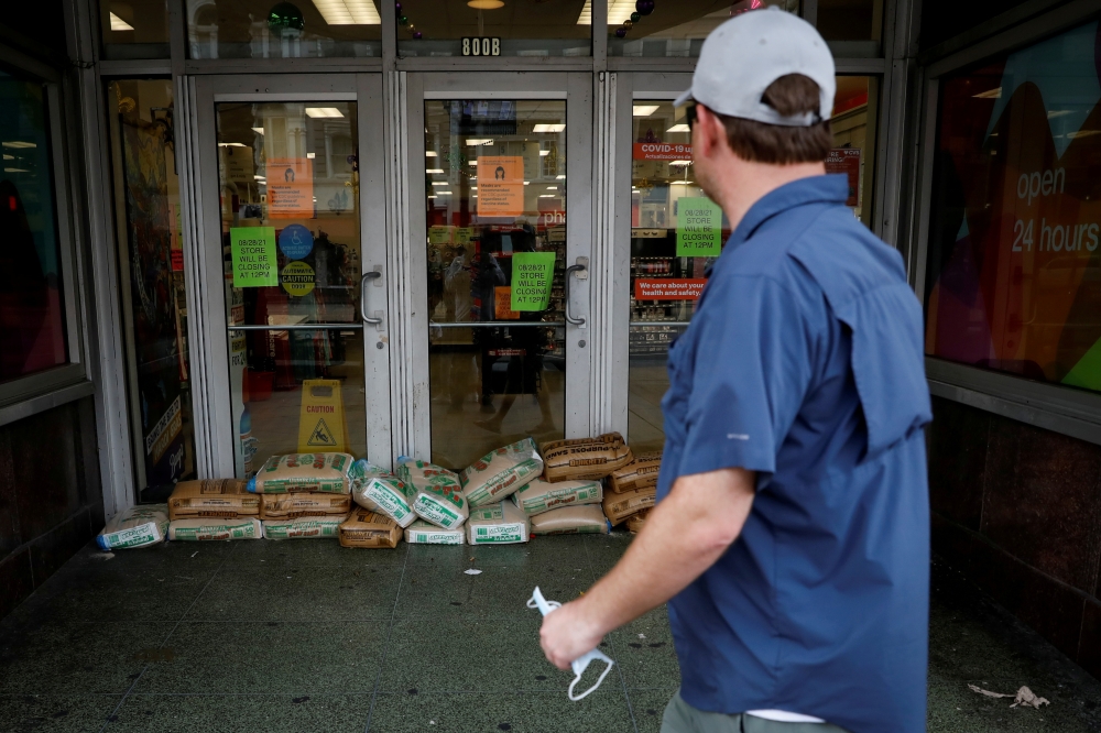 A man looks at sandbags at the entrance of a store in preparation for Hurricane Ida, in New Orleans, Louisiana, U.S. August 28, 2021. REUTERS/Marco Bello