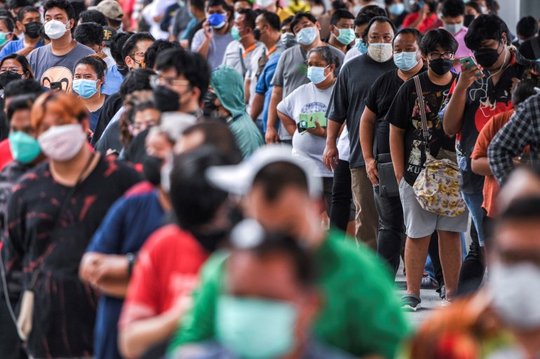 People wearing protective masks queue outside the Central Vaccination Center as Thailand opens walk-in first dose of the AstraZeneca coronavirus disease (COVID-19) vaccination scheme for elders, people with a minimum weight of 100 kilograms and pregnant w