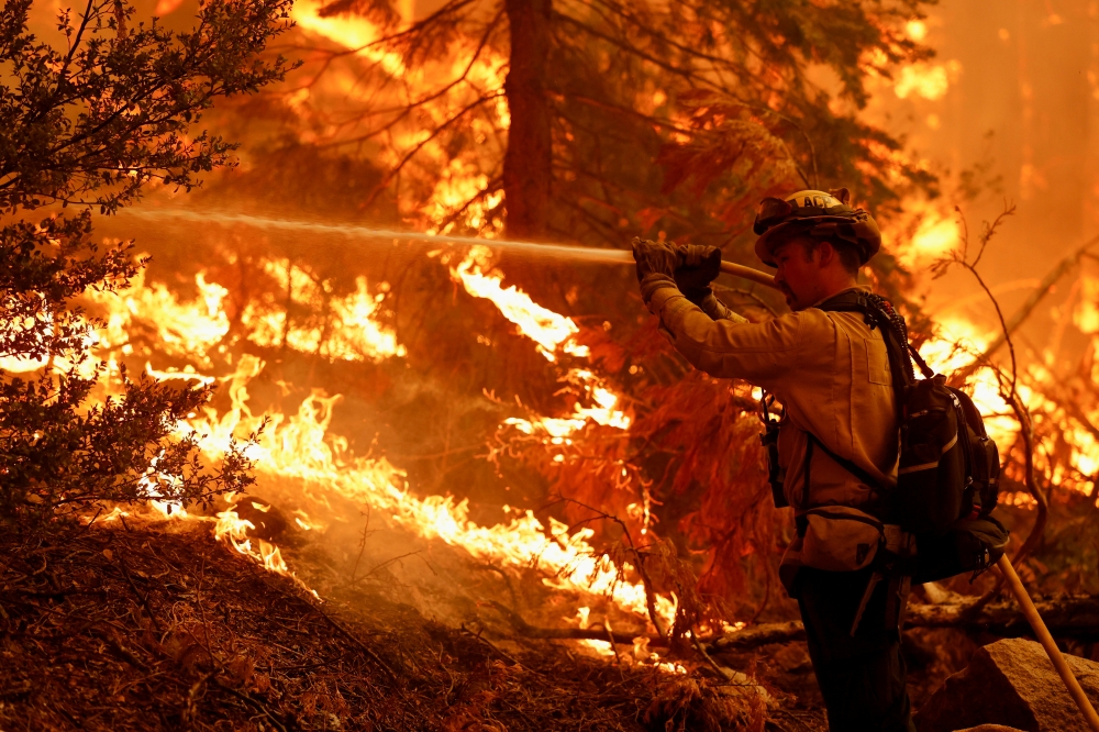 A firefighter battles flames to protect structures from Caldor Fire, in Strawberry, California, U.S., August 28, 2021. REUTERS/Fred Greaves