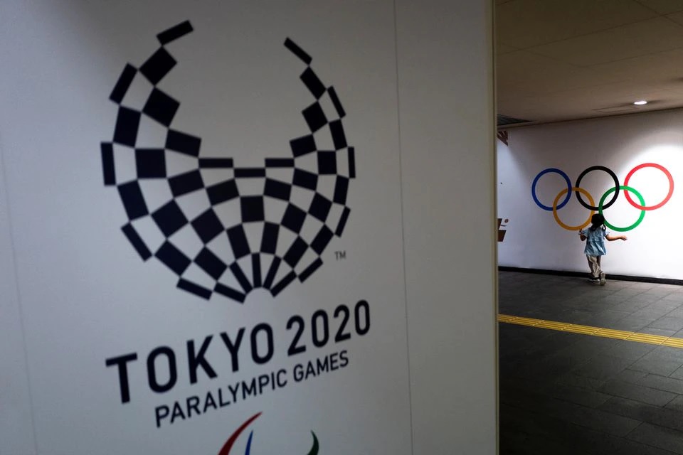 A girl runs past Olympic rings and the logo of Tokyo 2020 Paralympic Games amid the coronavirus disease (COVID-19) pandemic in Tokyo, Japan, August 16, 2021. REUTERS/Athit Perawongmetha