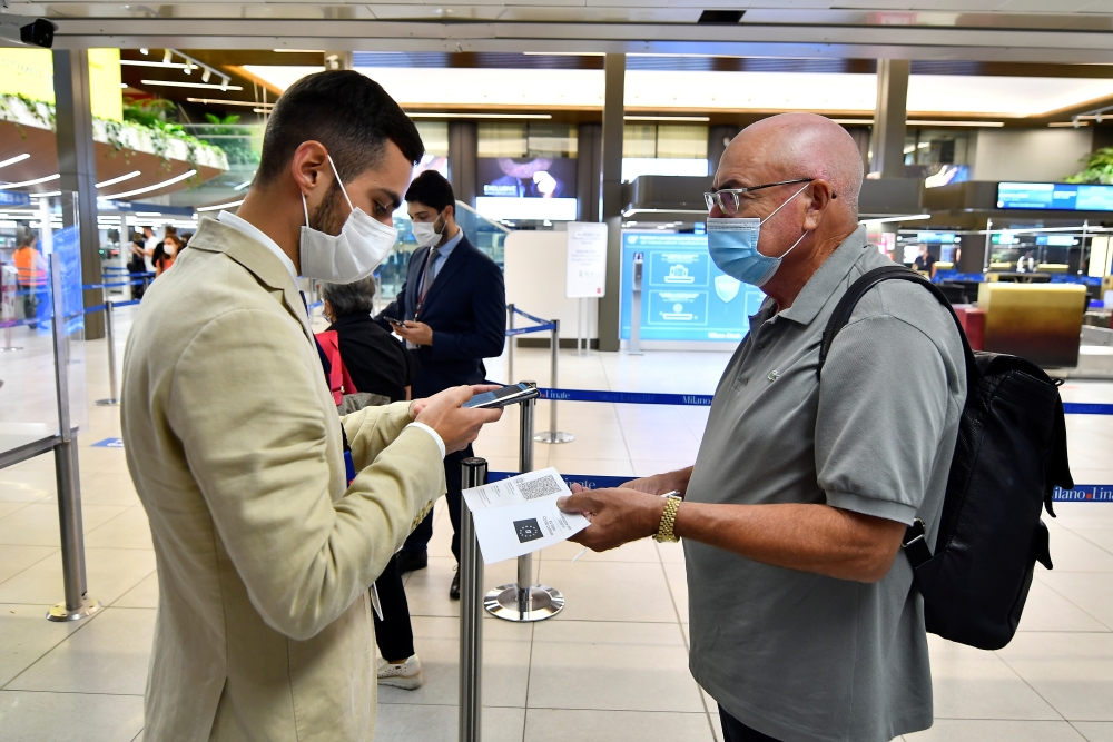 A man shows his COVID-19 certificate at Linate Airport in Milan, Italy, September 1, 2021. REUTERS/Flavio Lo Scalzo