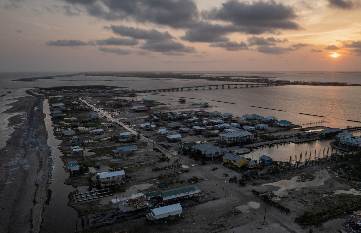 Houses, businesses and beaches are seen damaged at the entrance to Grand Isle at sunset after the town and barrier island was left devastated by Hurricane Ida as seen in this aerial image over Louisiana, U.S., September 2, 2021. Picture taken with a drone