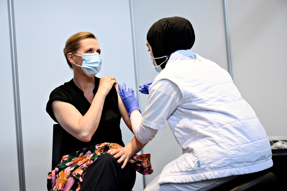 Danish Prime Minister Mette Frederiksen is vaccinated against COVID-19 by vaccinator Huda Beklar in Oksnehallen in Copenhagen, Denmark June 4, 2021. Philip Davali/Ritzau Scanpix/via REUTERS