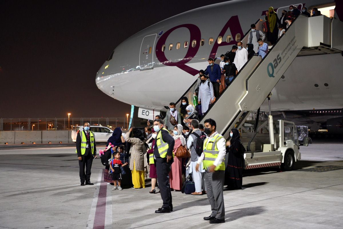 Passengers disembark a Qatar Airways plane arriving from Kabul, Afghanistan, the first international commercial flight since the U.S. withdrawal from Afghanistan, in Doha, Qatar, September 9, 2021. REUTERS/Nooman Ben Amor