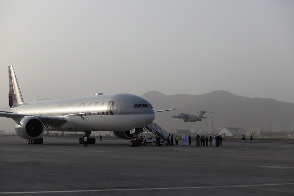 A Qatari cargo plane takes off behind a Qatar Airways commercial flight boarding passengers at the international airport in Kabul, Afghanistan, September 10, 2021. WANA (West Asia News Agency) via REUTERS