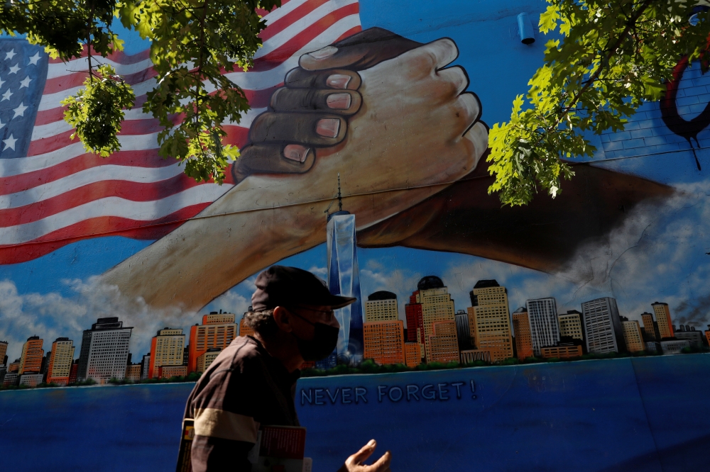 A man walks by a 9/11 memorial mural in the Bronx borough of New York City, U.S., September 10, 2021. REUTERS/Shannon Stapleton