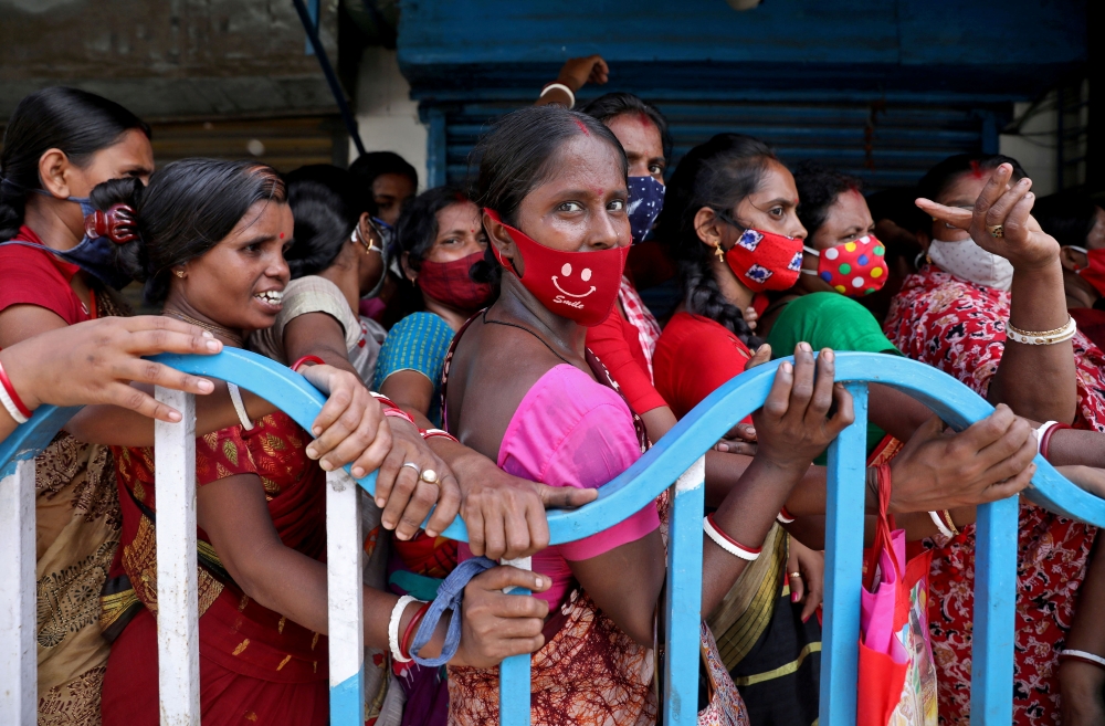 Women wait to receive a dose of COVISHIELD vaccine, a coronavirus disease (COVID-19) vaccine manufactured by Serum Institute of India, outside a vaccination centre in Kolkata, India, August 31, 2021. REUTERS/Rupak De Chowdhuri/File Photo