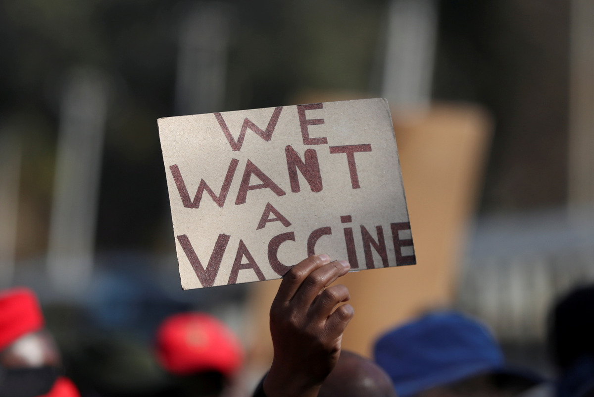 FILE PHOTO: A person holds a placard as supporters of the Economic Freedom Fighters (EFF) march to demand a rollout of coronavirus disease (COVID-19) vaccines, in Pretoria, South Africa June 25, 2021. REUTERS/Siphiwe Sibeko/File Photo
