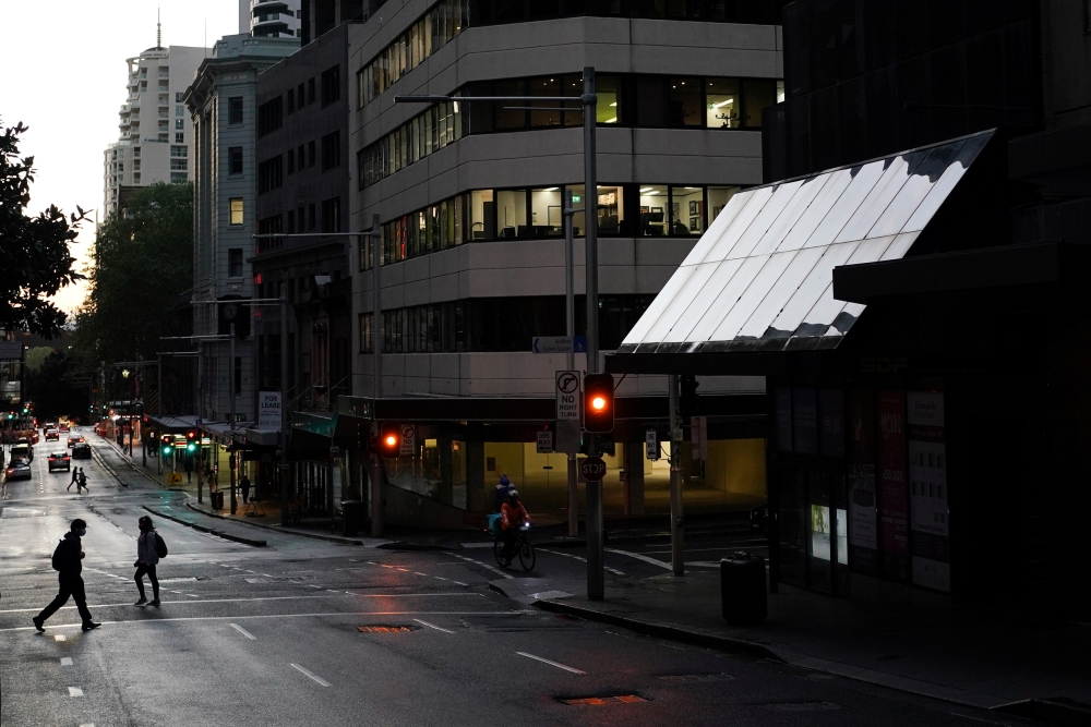 Pedestrians cross an intersection in the city centre during a lockdown to curb the spread of a coronavirus disease (COVID-19) outbreak in Sydney, Australia, September 14, 2021. REUTERS/Loren Elliott