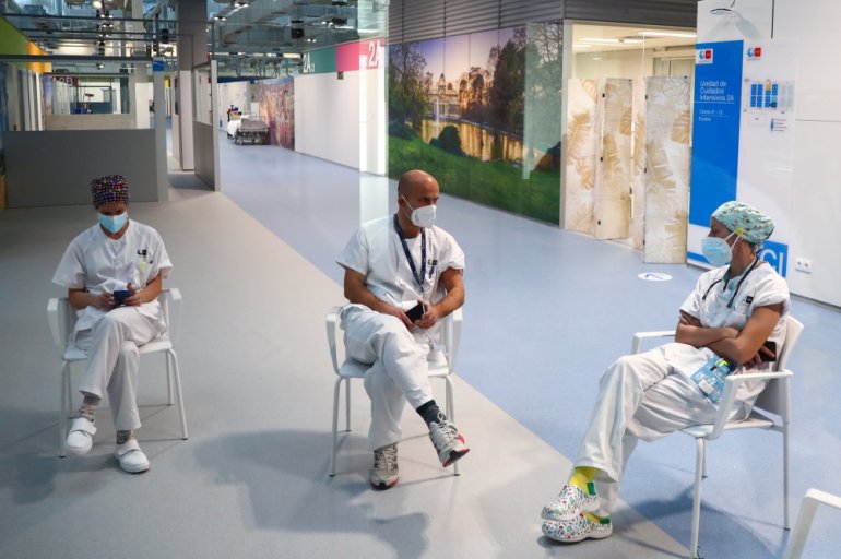 Health workers wait after receiving their injections with a dose of the Pfizer-BioNTech COVID-19 vaccine, as the coronavirus disease (COVID-19) outbreak continues, at Enfermera Isabel Zendal hospital in Madrid, Spain January 11, 2021. Picture taken throug