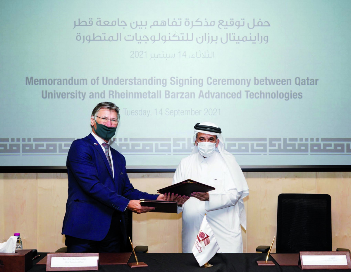 Qatar University Vice-President  of Academic Affairs Dr. Omar Al Ansari and  Chief Executive Of?cer  of Rheinmetall Barzan Advanced Technologies Andre Conradie exchanging documents after the signing of Memorandum of Understanding.
