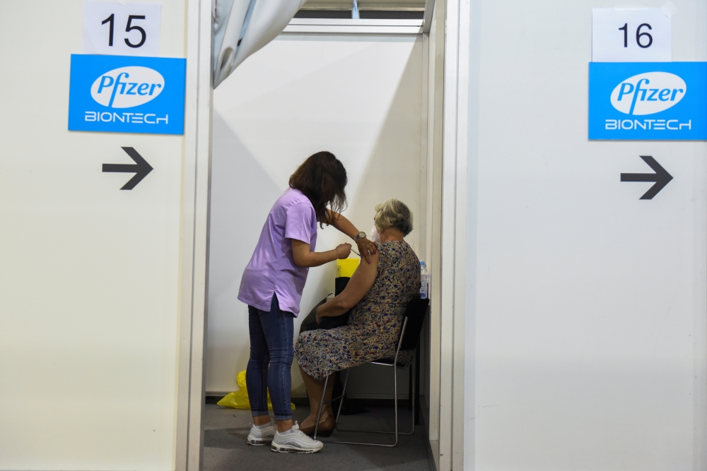 A healthcare worker administers the third dose of Pfizer's coronavirus disease (COVID-19) vaccine to a woman at Belgrade Fair vaccination center in Belgrade, Serbia, August 25, 2021. REUTERS/Zorana Jevtic./File Photo