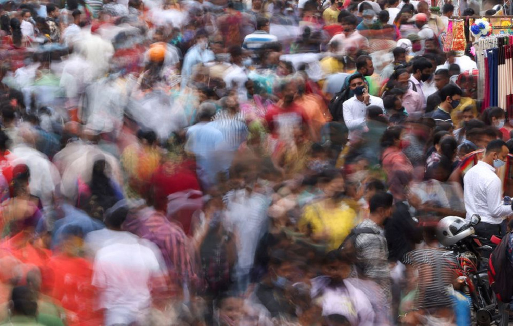 A man speaks on the phone as people walk past him at a crowded market amidst the spread of the coronavirus disease (COVID-19) in Mumbai, India, September 5, 2021. REUTERS/Francis Mascarenhas/Files