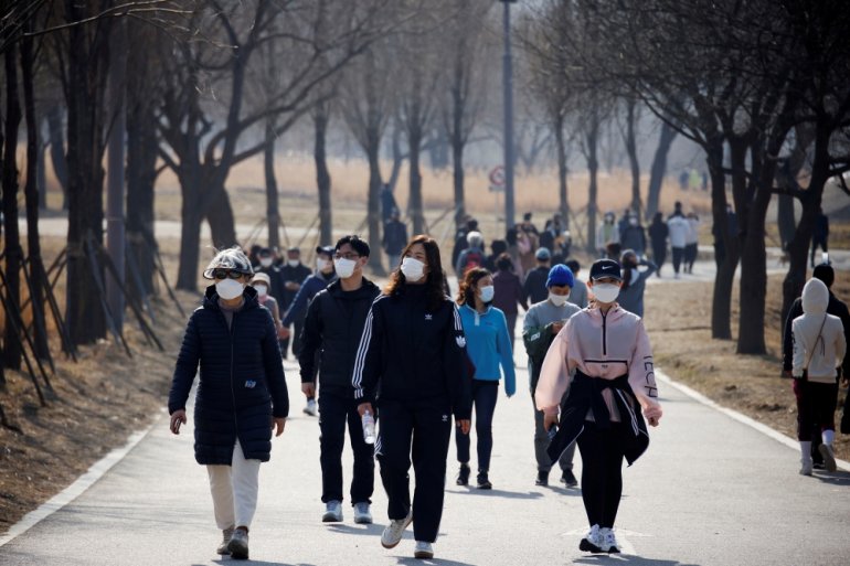 People wearing masks take a walk amid the coronavirus disease (COVID-19) pandemic at a Hanriver Park in Seoul, South Korea, February 21, 2021. REUTERS/Kim Hong-Ji/File Photo