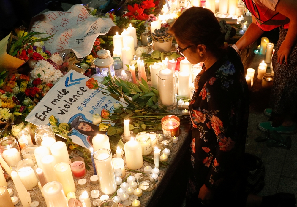 A placard is seen among flowers and candles during a vigil in memory of Sabina Nessa, a teacher who was murdered in Pegler Square, in London, Britain September 24, 2021. Reuters/Peter Nicholls