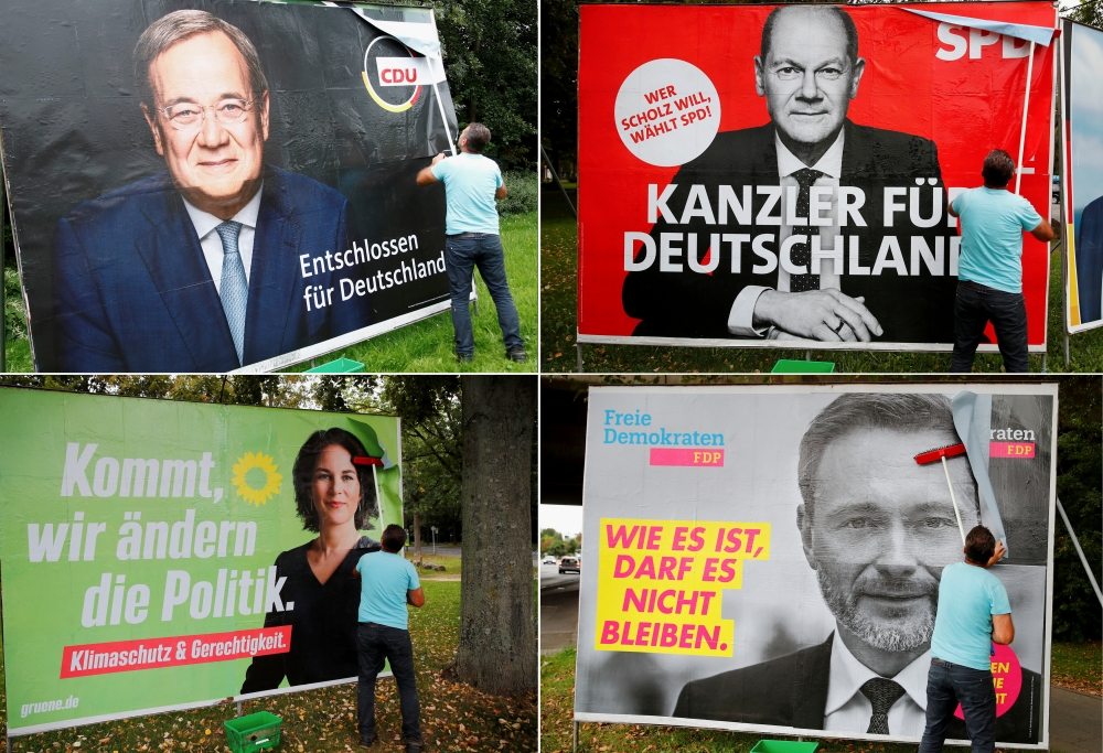 File photo: A combination of four images shows placards of Germany’s top candidates for the September 26 German general elections being placed on large boards. The top row shows Armin Laschet of the Christian Democratic Union Party CDU and Olaf Scholz of 