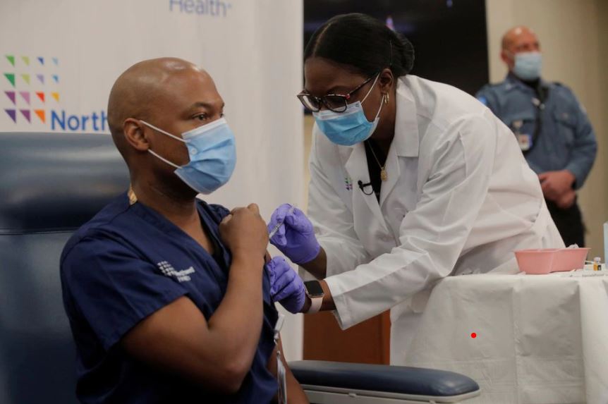 FILE PHOTO: Dr Yves Duroseau from Lennox Hill Hospital is inoculated with the Pfizer coronavirus disease (COVID-19) vaccine by Dr. Michelle Chester from Northwell Health at Long Island Jewish Medical Center in New Hyde Park, New York, U.S., December 14, 2