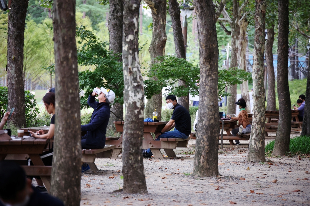 People rest as they keep social distancing to avoid the spread of the coronavirus disease (COVID-19) at a park in Seoul, South Korea, September 27, 2021. REUTERS/Kim Hong-Ji