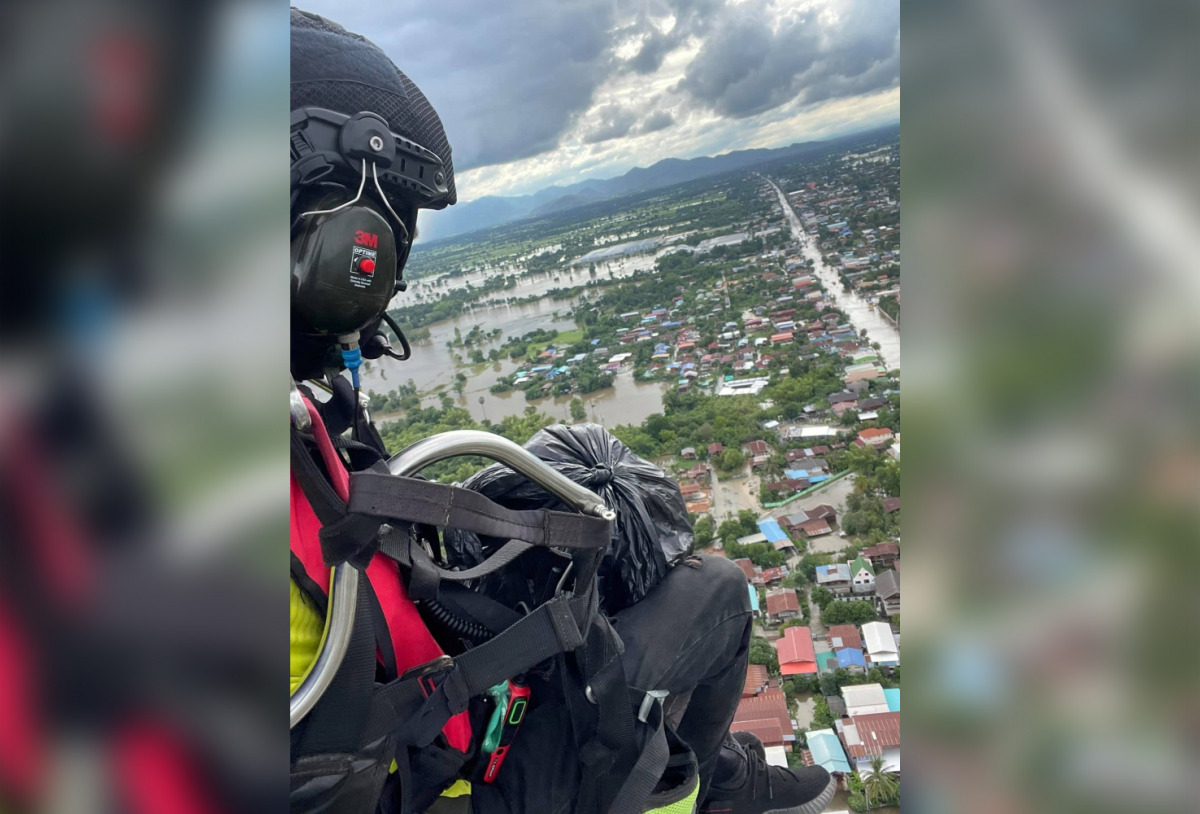 Powered paraglider delivers supplies to residents affected by flood in Sukhothai province, Thailand September 26, 2021 in this picture obtained from social media on September 28, 2021. The Charity Of Phitsanulok Association/via REUTERS