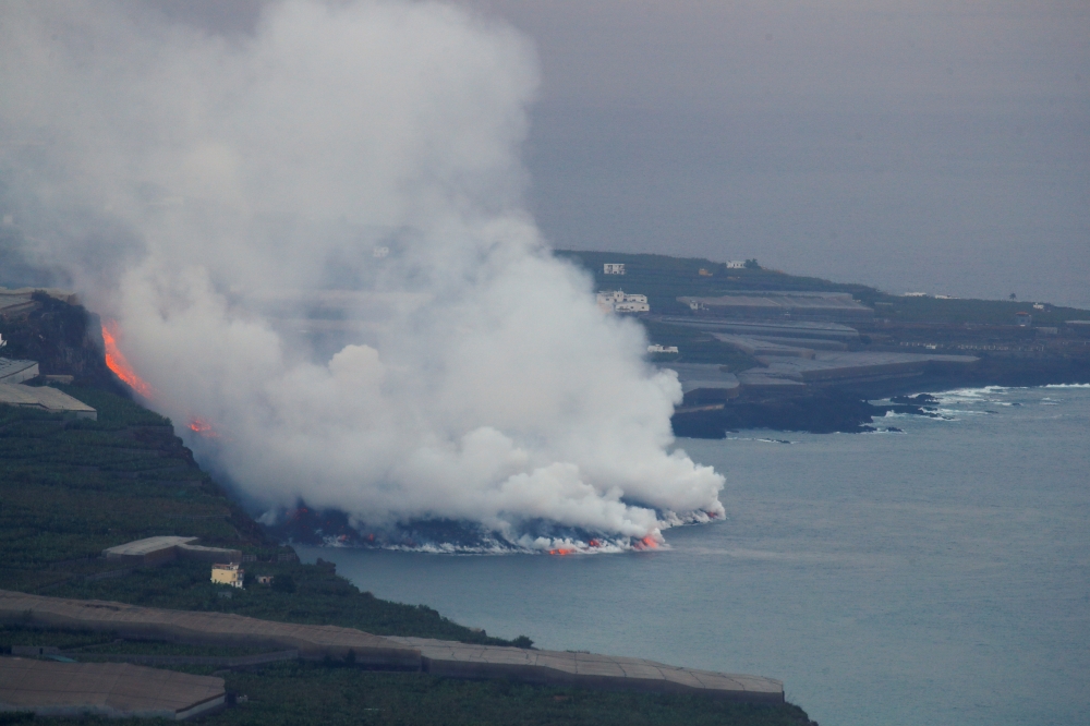 Lava flows into the sea, as seen from Tijarafe, following the eruption of a volcano on the Canary Island of La Palma, Spain, September 29, 2021. REUTERS/Borja Suarez