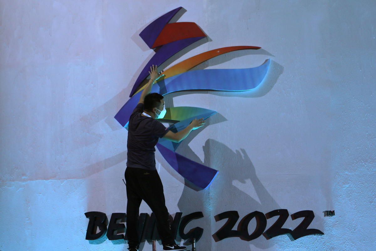 FILE PHOTO: A man adjusts an emblem of the Beijing 2022 Winter Olympic Games before a ceremony unveiling the slogan, in Beijing, China September 17, 2021. REUTERS/Tingshu Wang/File Photo
