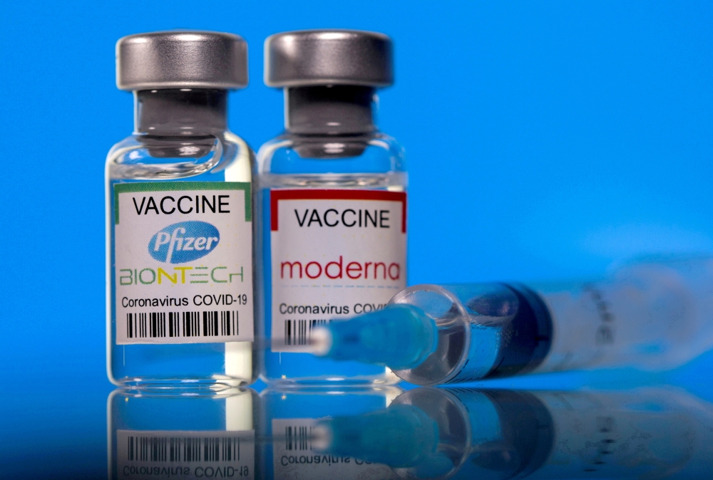 Vials with Pfizer-BioNTech and Moderna coronavirus disease (COVID-19) vaccine labels are seen in this illustration picture taken March 19, 2021. REUTERS/Dado Ruvic/Illustration/File Photo