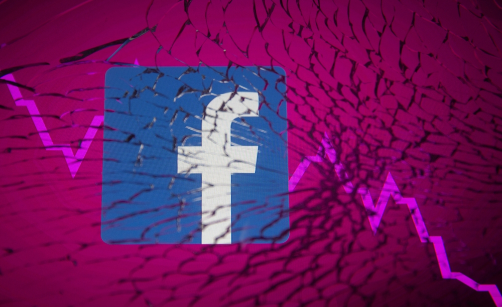Facebook logo and stock graph are displayed through broken glass in this illustration taken October 4, 2021. (REUTERS/Dado Ruvic/Illustration)