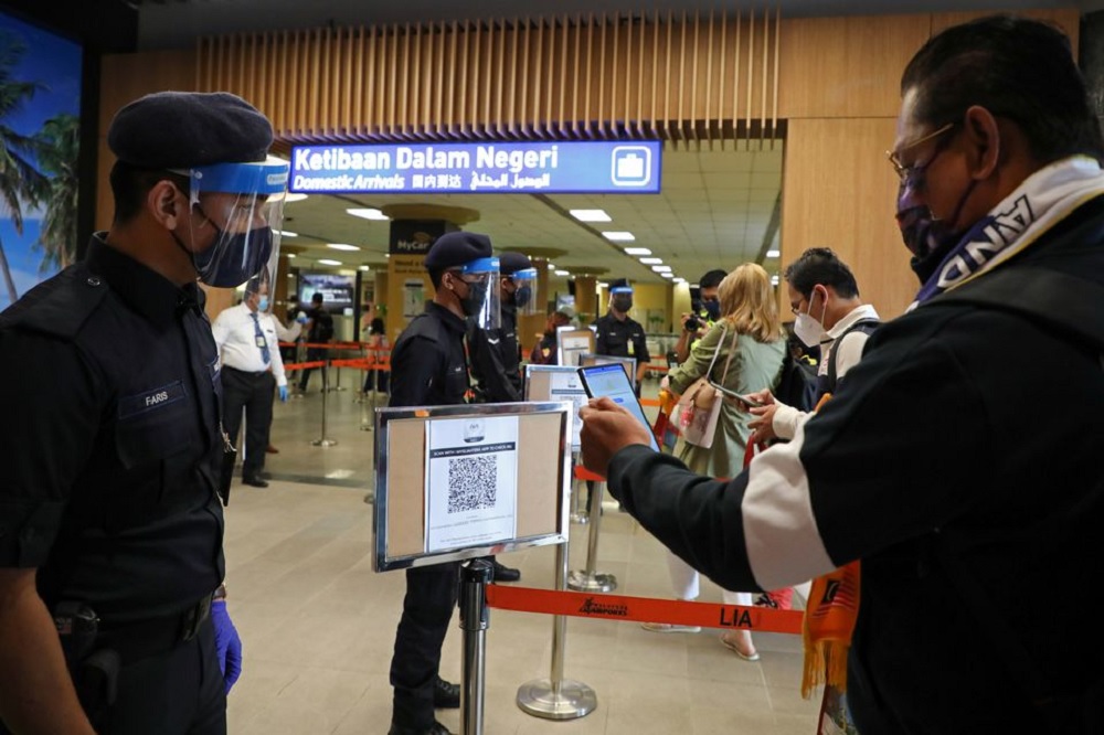 A tourist scans a QR code to check in upon arriving at the airport as Langkawi reopens to domestic tourists, amid the coronavirus disease (COVID-19) pandemic in Malaysia September 16, 2021. REUTERS/Lim Huey Teng