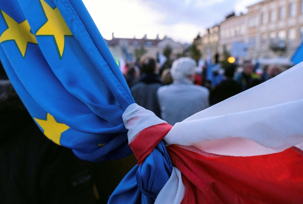 The flags of Poland and European Union are tied together during a rally in support of Poland's membership in the European Union after the country's Constitutional Tribunal ruled on the primacy of the constitution over EU law, undermining a key tenet of Eu