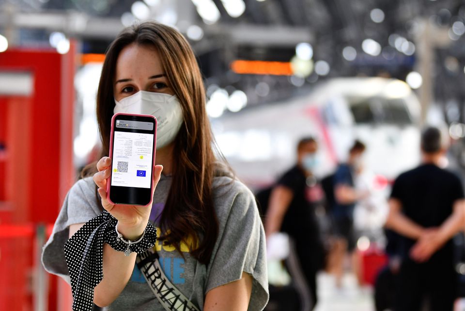 A woman shows her digital COVID-19 certificate at a train station in Milan, Italy, September 1, 2021. REUTERS/Flavio Lo Scalzo