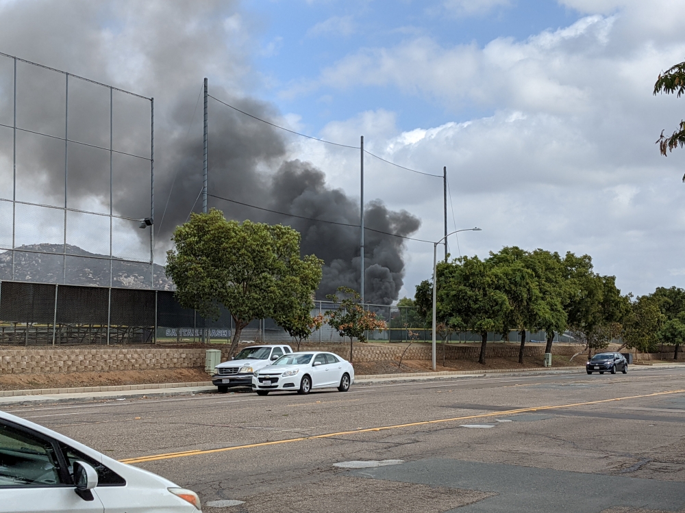 Smoke billows after a plane crash in Santee, California, U.S., October 11, 2021. Courtesy of Ryan Graves/Handout via REUTERS
