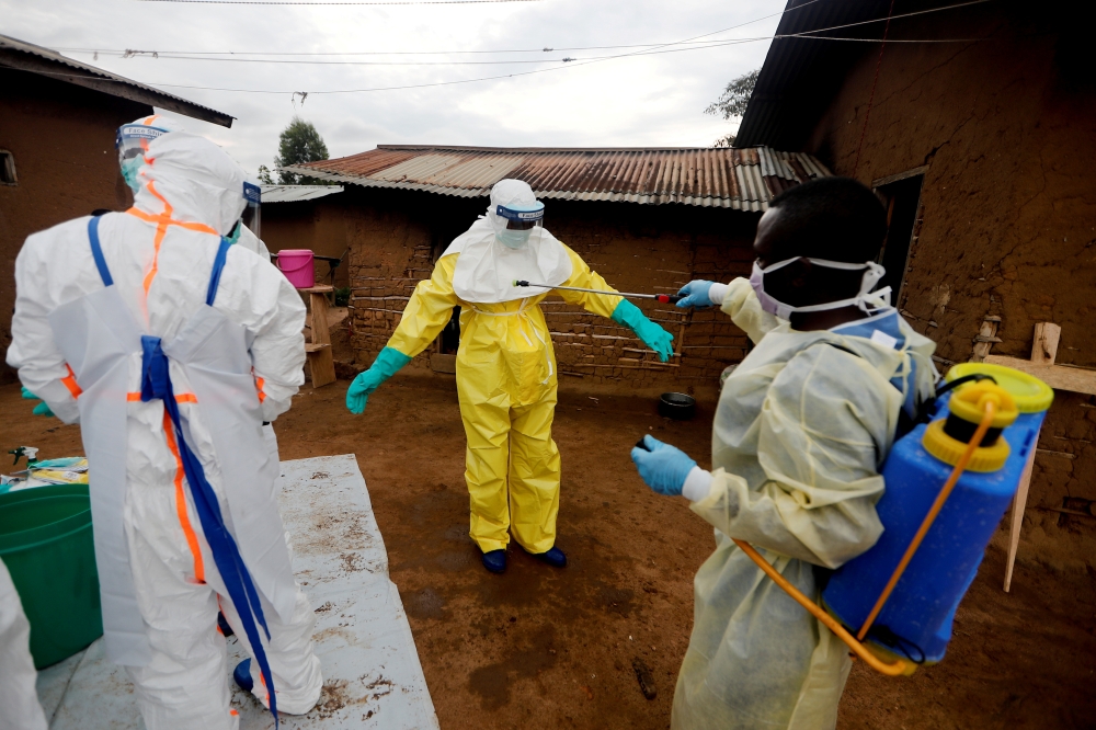 Kavota Mugisha Robert, a healthcare worker, who volunteered in the Ebola response, decontaminates his colleague after he entered the house of 85-year-old woman, suspected of dying of Ebola, in the eastern Congolese town of Beni in the Democratic Republic 