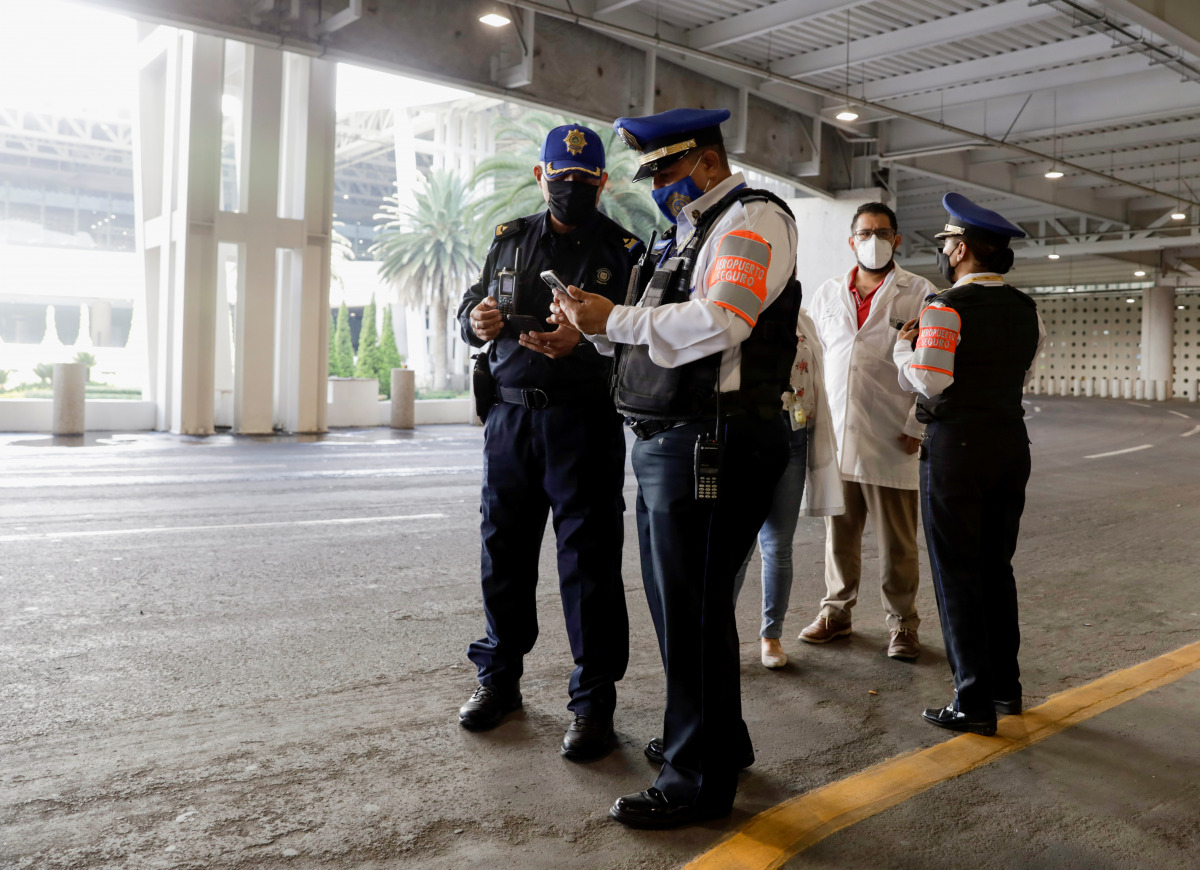 Agents of the city's prosecutors office and police officers collect information outside the airport after an attempted robbery turned into a shootout close to Mexico City's international airport on Friday morning, in which an alleged attacker was killed a