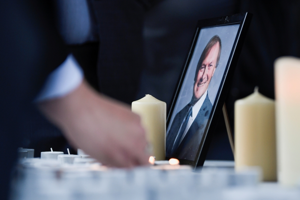People light candles during a vigil for MP David Amess, who was stabbed to death during a meeting with constituents, at Civic Centre in Southend-on-Sea, Britain October 16, 2021. REUTERS/Tony O'Brien