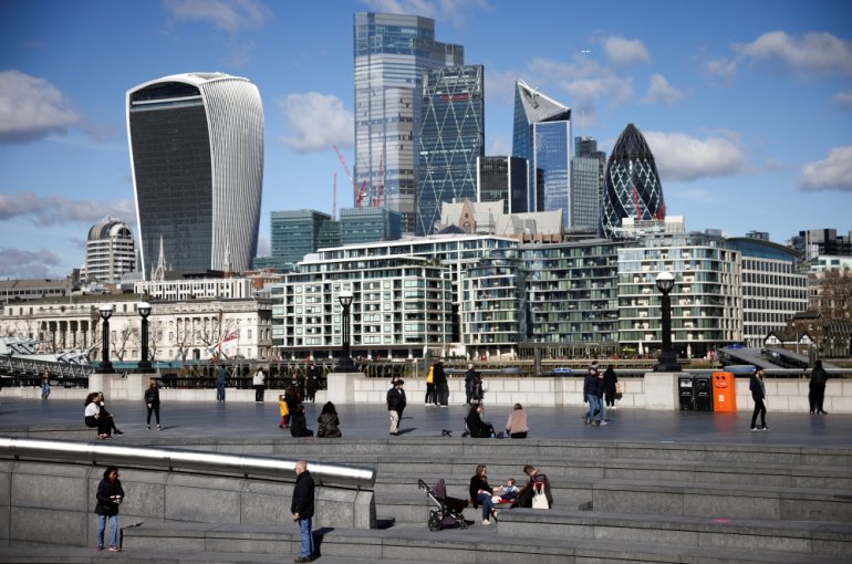 The City of London financial district can be seen as people walk along the south side of the River Thames, amid the coronavirus disease (COVID-19) outbreak in London, Britain, March 19, 2021. REUTERS/Henry Nicholls//File Photo
