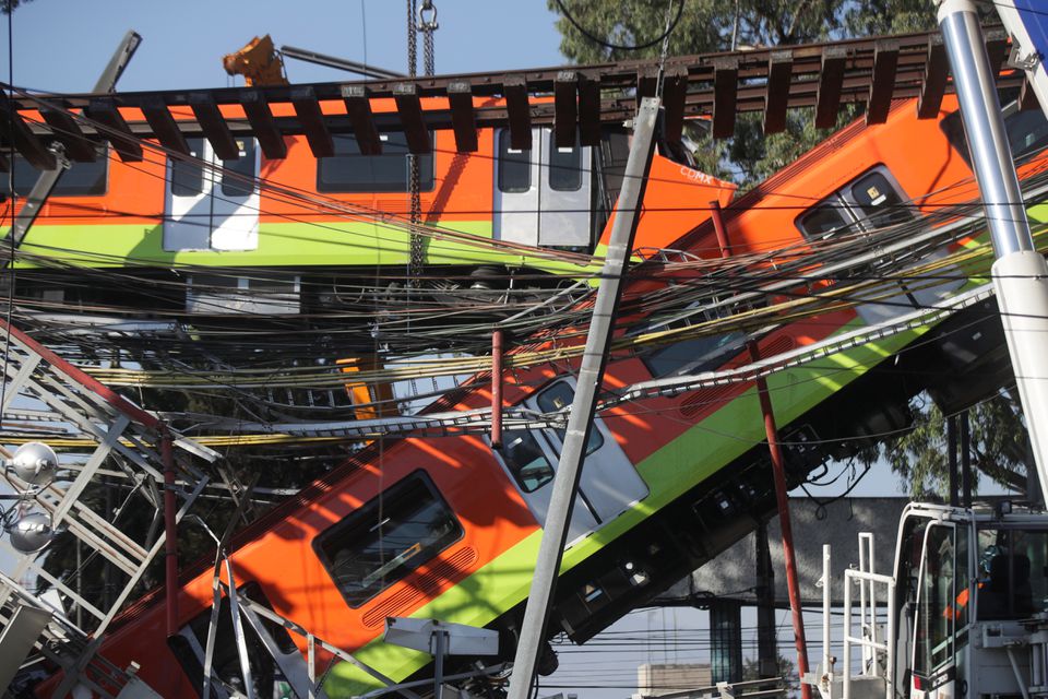 Workers move a train car from a site where an overpass for a metro partially collapsed with train cars on it at Olivos station in Mexico City, Mexico May 4, 2021. REUTERS/Henry Romero