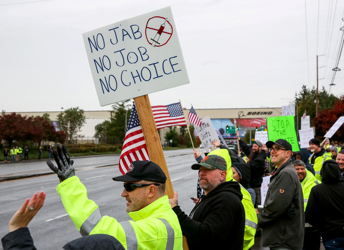 FILE PHOTO: Boeing employees and others line the street with signs and American flags as they protest the company's coronavirus disease (COVID-19) vaccine mandate, outside the Boeing facility in Everett, Washington, October 15, 2021. REUTERS/Lindsey Wasso
