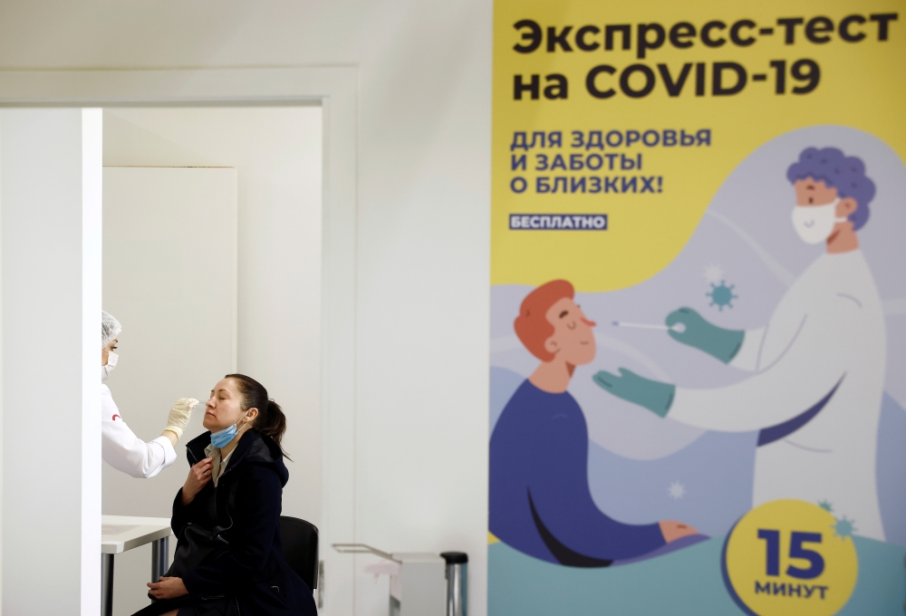 A woman undergoes a free coronavirus disease (COVID-19) rapid antigen test at a testing centre in the State Department Store, GUM, in Moscow, Russia October 18, 2021. REUTERS/Maxim Shemetov/File Photo