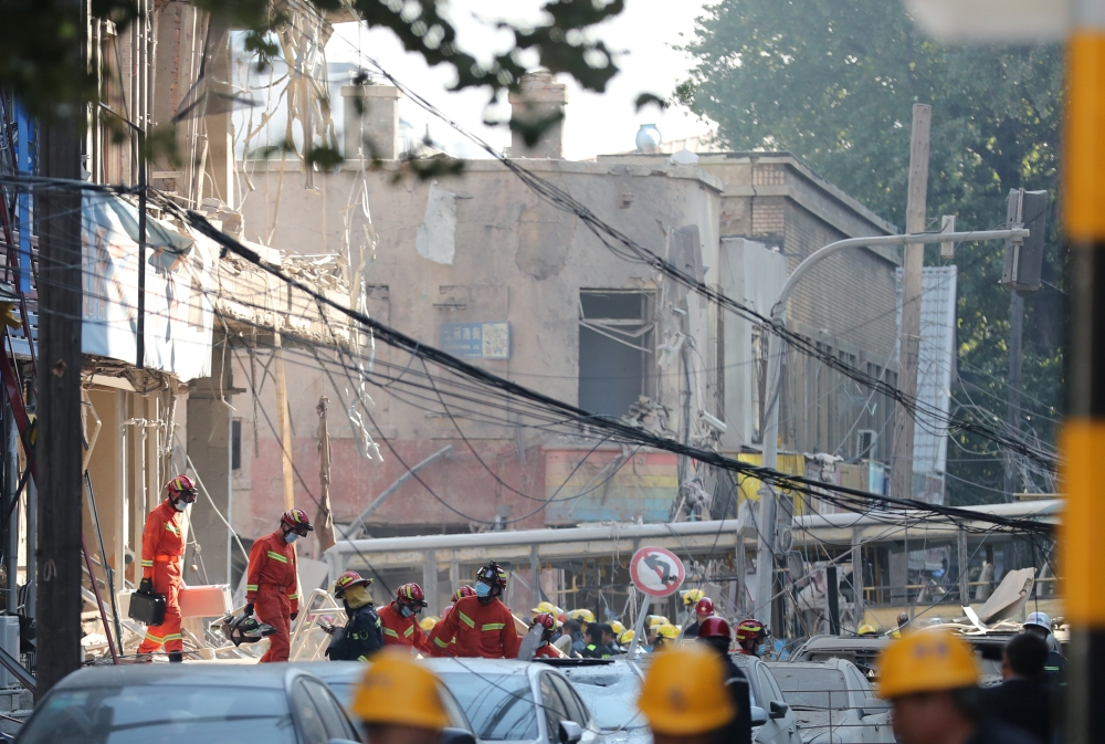 Rescue workers are seen at the site following a gas explosion at a restaurant in Shenyang, Liaoning province, China October 21, 2021. cnsphoto via REUTERS