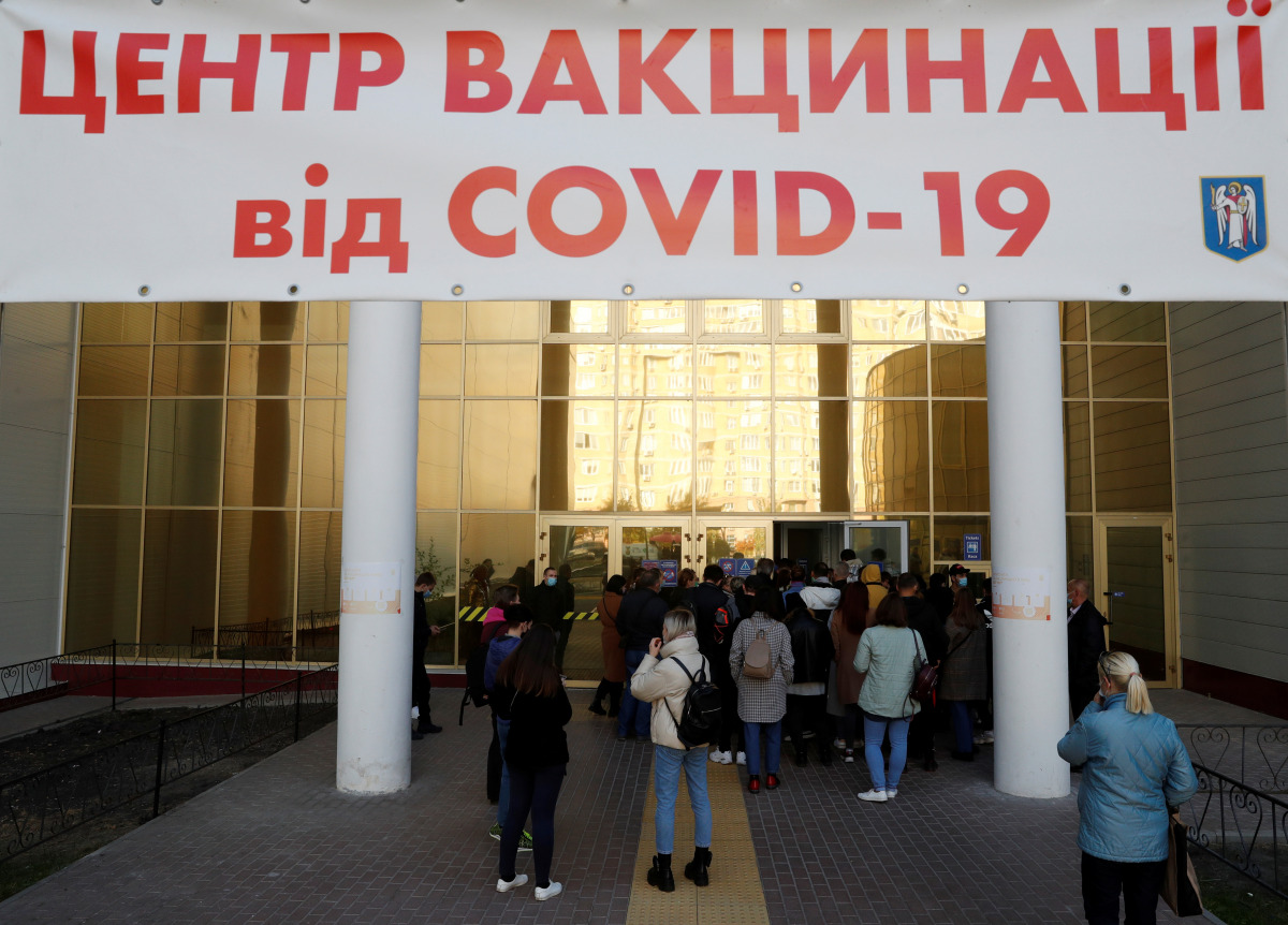 People wait to receive a vaccine against the coronavirus disease (COVID-19) outside a vaccination centre in Kyiv, Ukraine October 21, 2021. REUTERS/Valentyn Ogirenko
