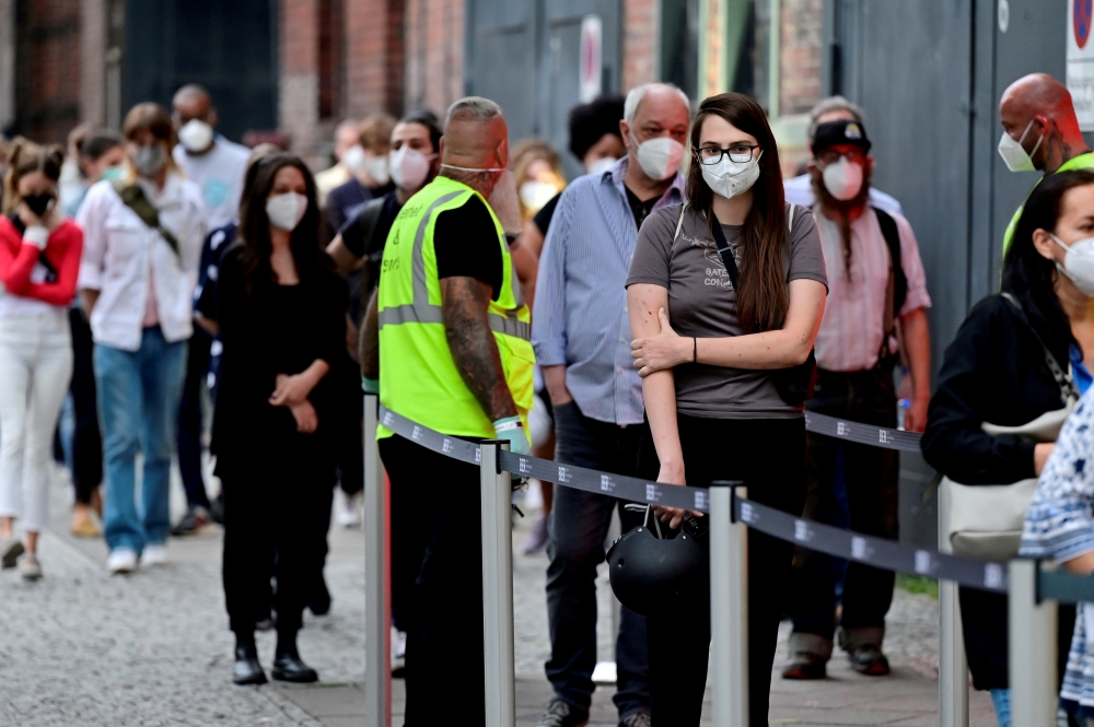 People queue to receive a vaccine against the coronavirus disease (Covid-19) in Berlin, Germany, August 9, 2021. John Macdougall/Pool via Reuters/File Photo