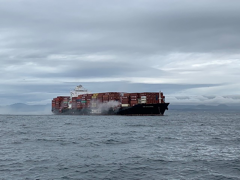 Smoke rises from the container ship Zim Kingston, burning from a fire on board, off the coast of Victoria, British Columbia, Canada October 23, 2021. Canadian Coast Guard/Handout via Reuters