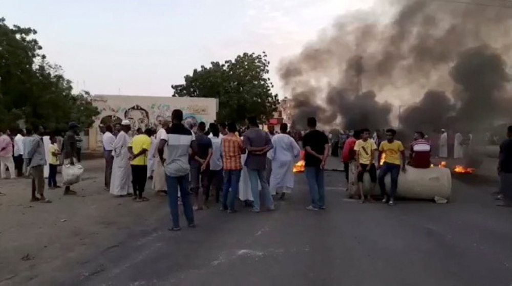 People gather around as smoke and fire are seen on the streets of Kartoum, Sudan, amid reports of a coup, October 25, 2021, in this still image from video obtained via social media