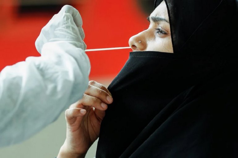 A health worker in personal protective equipment (PPE) collects a swab sample from a woman during a rapid antigen testing campaign for the coronavirus disease (COVID-19), at a railway station platform in Mumbai, India, August 27, 2021. REUTERS/Francis Mas
