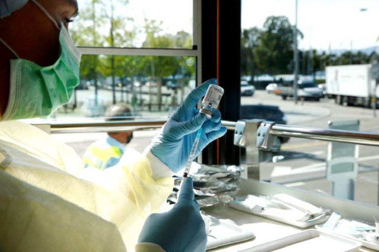 A health worker draws Moderna coronavirus disease (COVID-19) vaccine into a syringe inside the COVID-19 Impftram vaccination tram during a media presentation in Zurich, Switzerland September 14, 2021. REUTERS/Arnd Wiegmann/File Photo