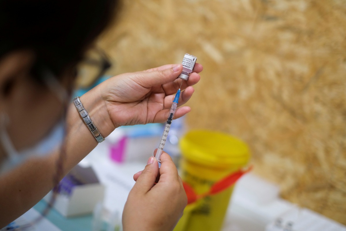 FILE PHOTO: A healthcare worker prepares a dose of the Pfizer coronavirus disease (COVID-19) vaccine at a vaccination centre in Seixal, Portugal, September 11, 2021. REUTERS/Pedro Nunes/File Photo
