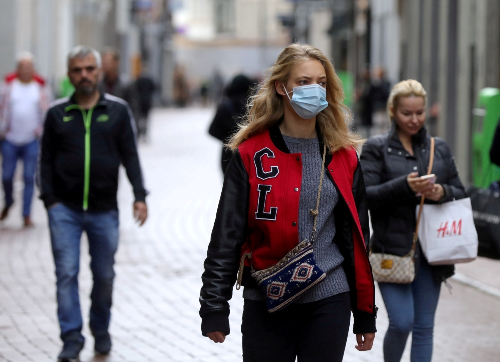 People with and without protective masks walk on the street while shopping as the spread of coronavirus disease (COVID-19) continues in Amsterdam, Netherlands October 7, 2020. Reuters/Eva Plevier/File Photo