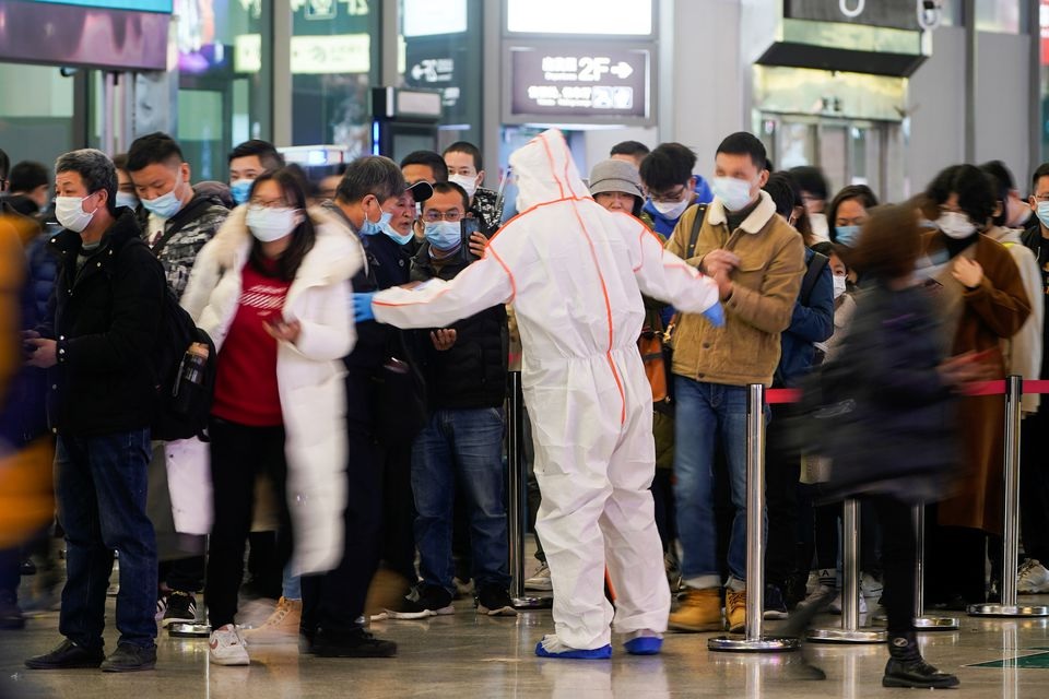 A security guard blocks an exit as he directs people to scan a QR code to track their health status at Shanghai Hongqiao Railway Station, following new cases of the coronavirus disease (COVID-19), in Shanghai, China, November 25, 2021. Picture taken November 25, 2021. REUTERS/Aly Song