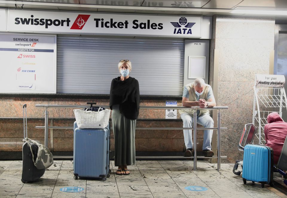 Passengers wait for confirmation of flights outside the Swissport Ticket Sales counter as several airlines stopped flying out of South Africa, amidst the spread of the new SARS-CoV-2 variant Omicron, at O.R. Tambo International Airport in Johannesburg, South Africa, November 28, 2021. REUTERS/ Sumaya Hisham/File Photo



