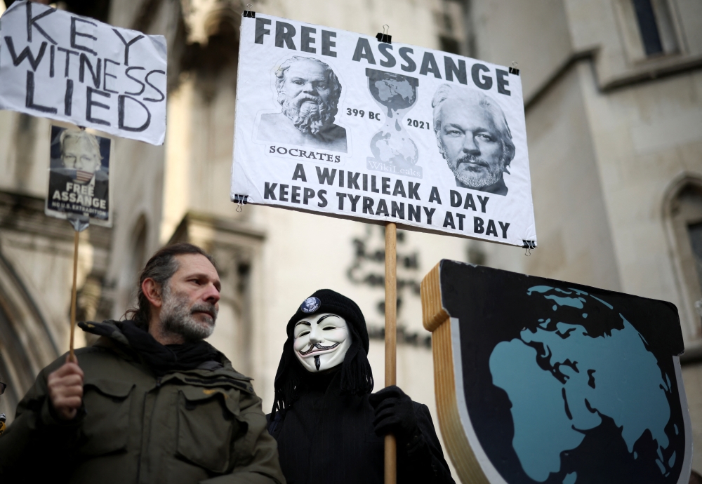 Supporters of Julian Assange hold signs outside the Royal Courts of Justice in London, Britain December 10, 2021. REUTERS/Henry Nicholls